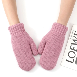 Close-up of pink knitted mittens with ribbed long cuffs and soft woolen texture