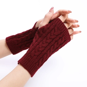 Detail of cable knit pattern on dark red fingerless arm warmers with a stylish textured weave