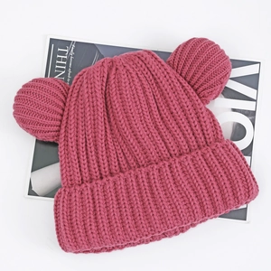 Detailed knit texture of pink winter hat with cute decorative ears on white background