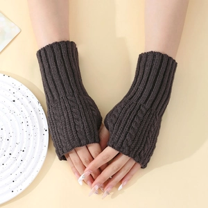 Détail de mitaines en tricot torsadé marron foncé montrant la texture de laine