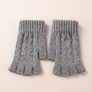Detailed knit texture of gray fingerless arm warmers with classic cable patterns