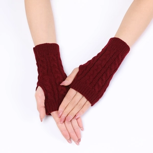 Detail of burgundy cable knit fingerless gloves with thumb hole and ribbed cuffs