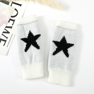 Gros plan détaillé de mitaines en tricot avec motif étoile noire sur fond blanc