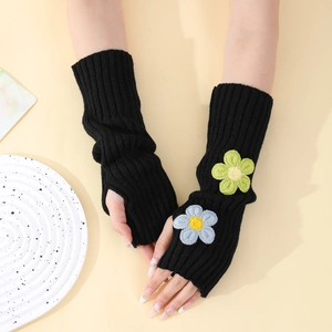 Close-up of black knitted fingerless gloves with light green and blue flower patches