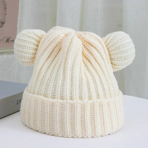 Close-up of thick ribbed knit texture and cute knitted bear ears on a cream winter hat