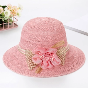 Detailed view of pink woven sun hat featuring silk floral decor and plaid ribbon bow