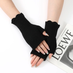 Detailed close-up of black ribbed knit fingerless gloves with elegant ruffled edges