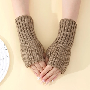 Gros plan des mitaines en tricot torsadé marron montrant la texture côtelée et la laine