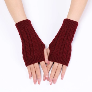 Detail of burgundy cable knit fingerless gloves showing warm textured crochet sleeves