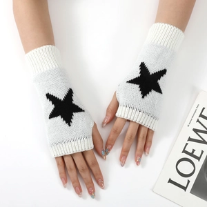 Vue détaillée de mitaines tricotées blanches avec un motif d'étoile noire brodé