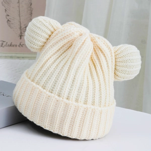 Close-up of off-white knitted beanie featuring cute bear ears and thick vertical ribbing