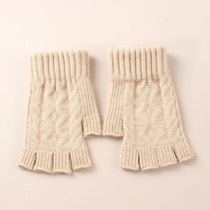Close-up of beige cable knit arm warmers showing soft wool texture and ribbed cuffs