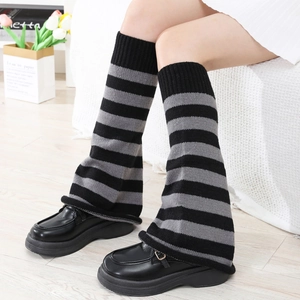 Y2K style striped knit leg warmers in black and grey paired with platform shoes