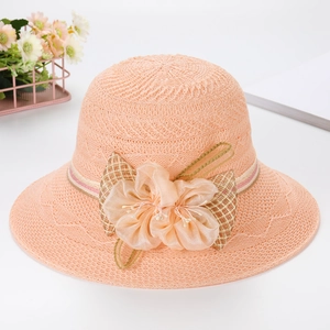 Detail of pink crochet sun hat featuring a large tulle flower with pearl and plaid bow