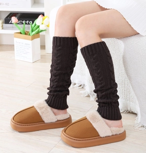 Close-up of cable knit leg warmers with cozy fur-lined platform slippers for winter