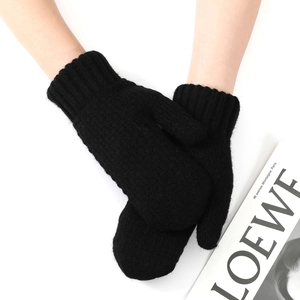 Close-up of thick black knitted mittens with elastic ribbed cuffs and warm texture