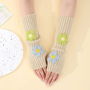 Detail view of beige knitted fingerless arm warmers with 3D floral crochet accents