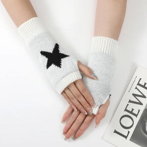 Détail de mitaines en tricot blanc avec motif étoile noire et poignets côtelés