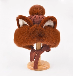 Detailed view of brown plush fox ear hat with soft faux fur texture and knitted ties