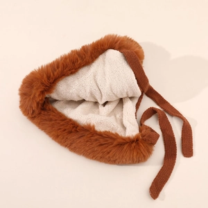 Detail of plush brown faux fur hat with soft white sherpa lining and knitted ties