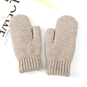 Close-up of oatmeal knit mittens featuring thick ribbed cuffs and soft wool texture