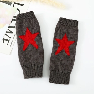 Détail de mitaines en tricot gris foncé avec motif étoile rouge et poignets côtelés