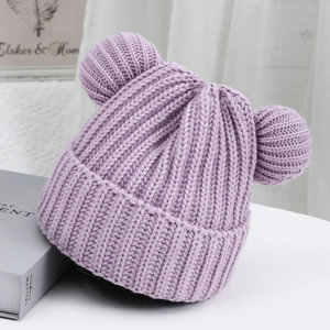Detailed knit texture of a lavender beanie with cute bear pom-pom ears on white surface