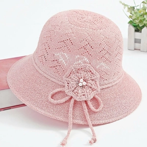 Detail of pink crochet sun hat featuring woven floral accents and faux pearl beads