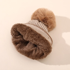 Dettaglio del berretto invernale in maglia con fodera in pile e pompon in ecopelliccia