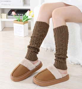 Detail of cable knit leg warmers and plush slippers for cozy winter home comfort