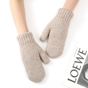 Close-up of thick knitted mittens in light brown showing the ribbed cuff texture