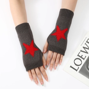 Détail du tricot de mitaines gris foncé ornées d'un motif étoile rouge vif