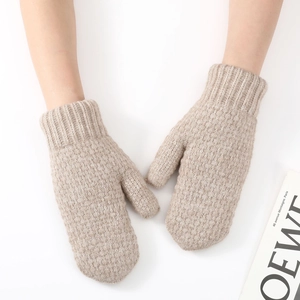 Close-up of thick khaki knit mittens showing detailed ribbed cuffs and warm wool texture
