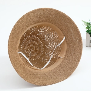 Women's brown straw sun hat featuring hollow breathable weave and elastic chin strap