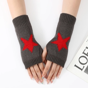 Détails de la maille tricotée des mitaines gris foncé avec un motif étoile rouge vif