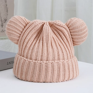 Detail of pink knitted beanie with bear ears and ribbed texture for winter warmth