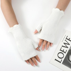 Close-up of white knitted fingerless gloves with ruffled edges and vertical ribbed texture