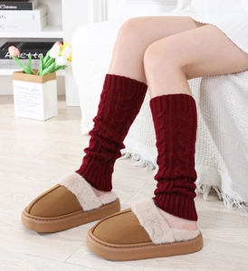 Detailed knit texture of thick cable pattern leg warmers with plush winter slippers