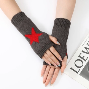 Détail de mitaines en tricot gris foncé avec motif étoile rouge et poignets côtelés