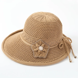 Detailed knit texture of khaki sun hat with crochet flower, pearls, and rhinestones