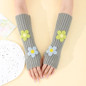Close-up of grey knit fingerless gloves featuring 3D flower embroidery and ribbed texture