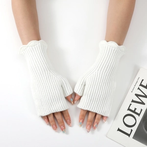 Close-up of white ribbed knit fingerless gloves with ruffled edges and thumb hole