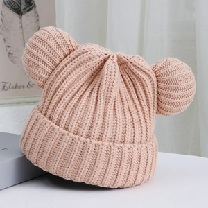 Detail of pink knitted baby hat with cute bear ears and ribbed texture for winter warmth