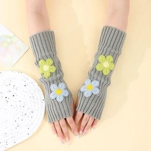 Close-up of grey knitted long fingerless gloves with 3D yellow and blue flower embroidery