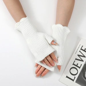 Detailed texture of off-white ribbed knit arm warmer with elegant ruffled edge detail