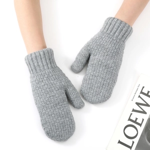 Detail of grey knitted mittens with soft texture and long ribbed cuffs for winter warmth