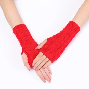 Macro shot of red cable knit fingerless gloves showing thick texture and thumb hole