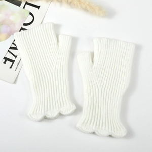 Macro detail of white ribbed knit fingerless gloves with elegant ruffled edges and thumb hole