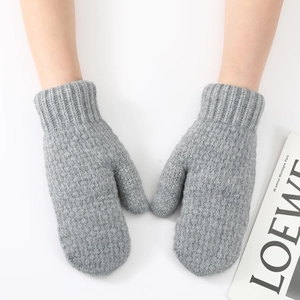 Close-up of grey chunky knit mittens with ribbed cuffs for winter warmth and wind protection