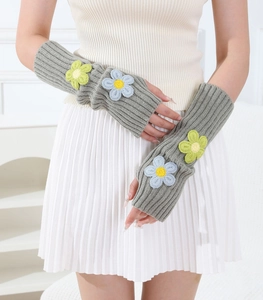 Close-up of gray knitted arm warmers featuring 3D floral embroidery and ribbed cuffs